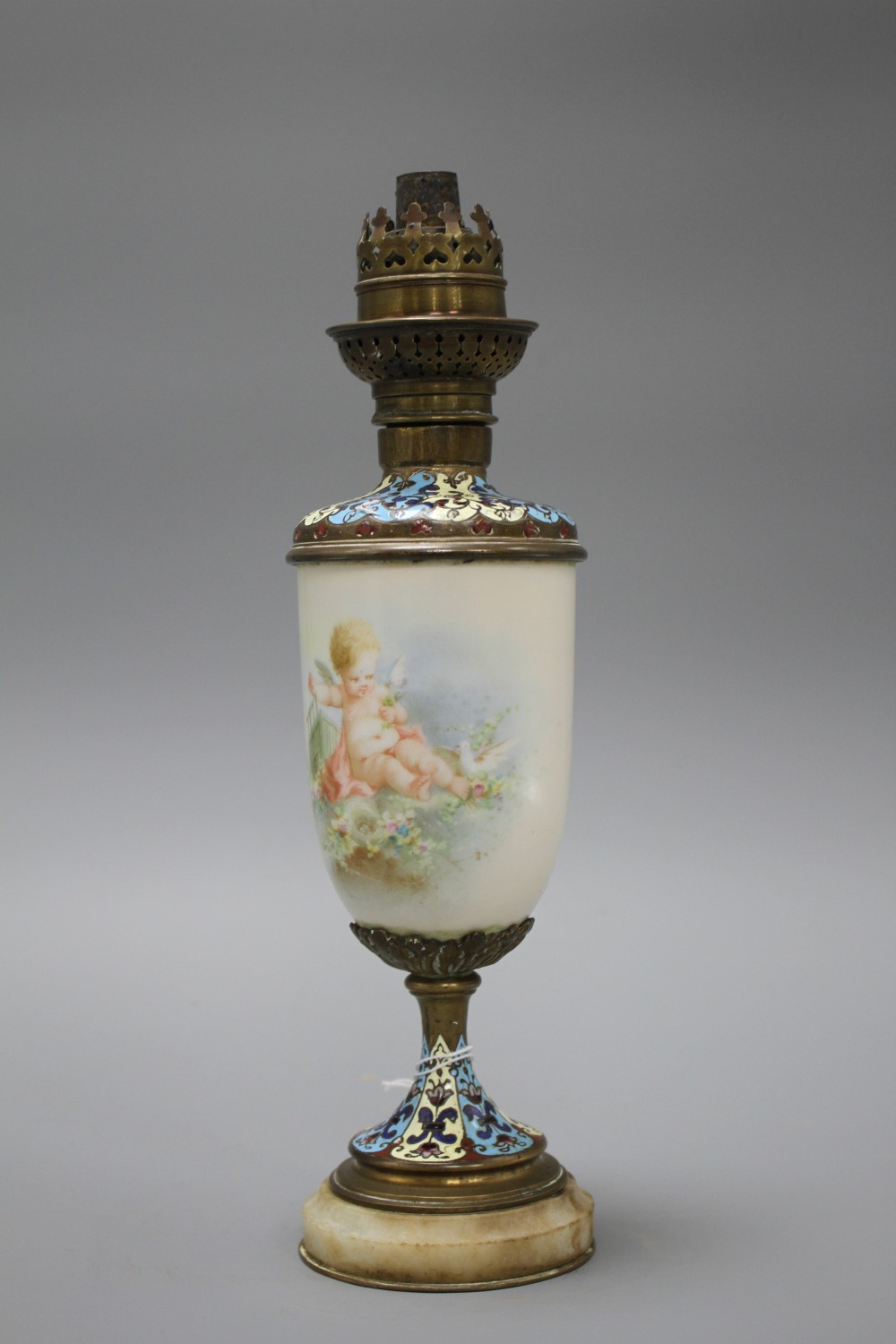 An early 20th century French champleve enamel bronze and ceramic lamp base, painted with a cherub, height 28cm